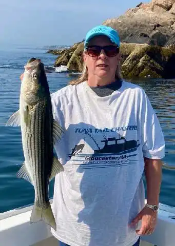 A couple poses with their surfboard—not standard gear for Tuna Tail Charters.